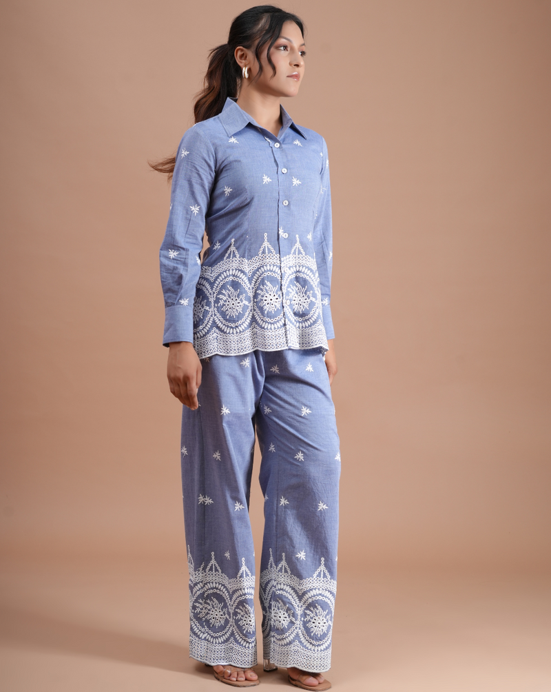 Woman wearing a blue traditional outfit with white patterns on a beige background