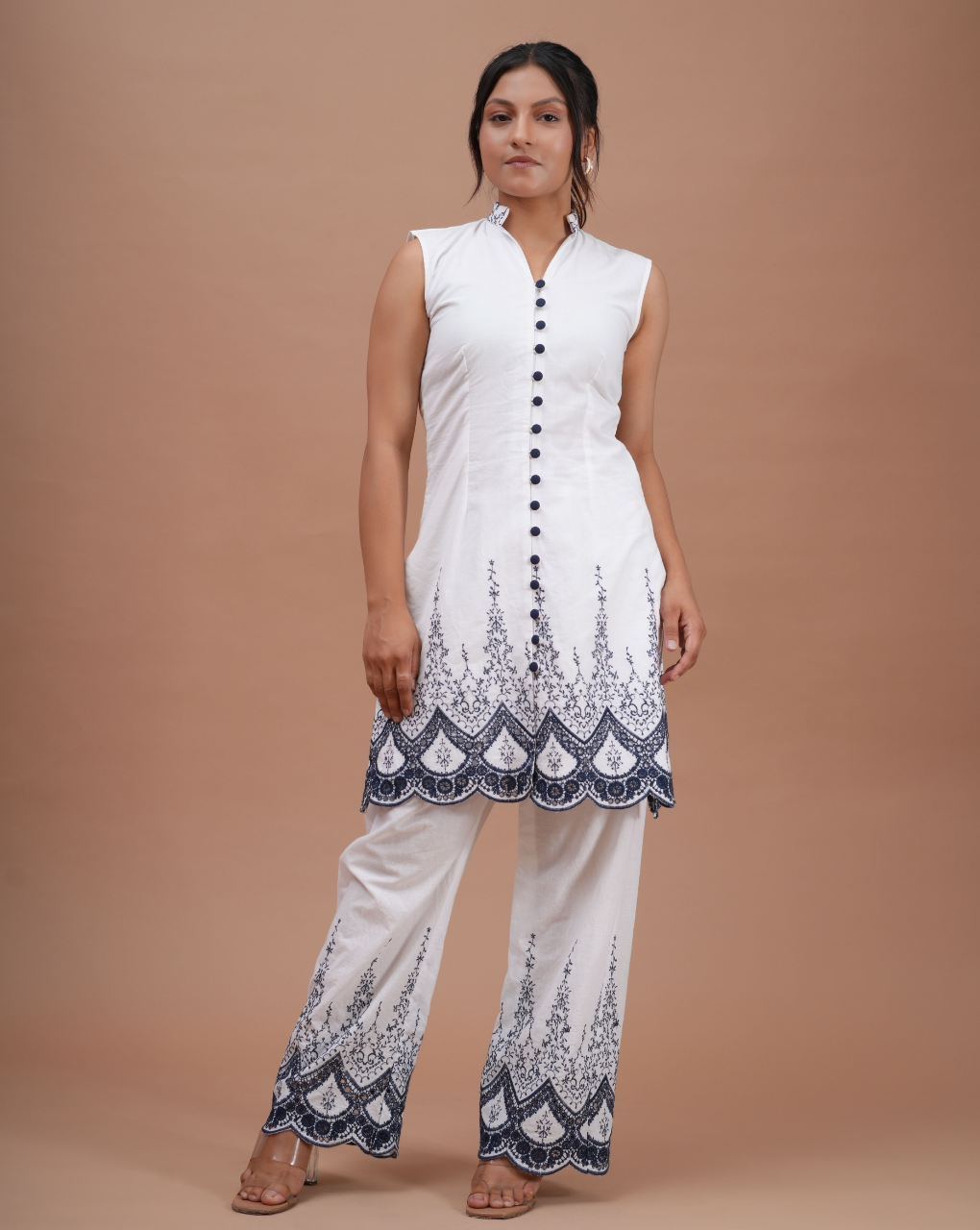 Woman wearing a white outfit with black patterns on a beige background