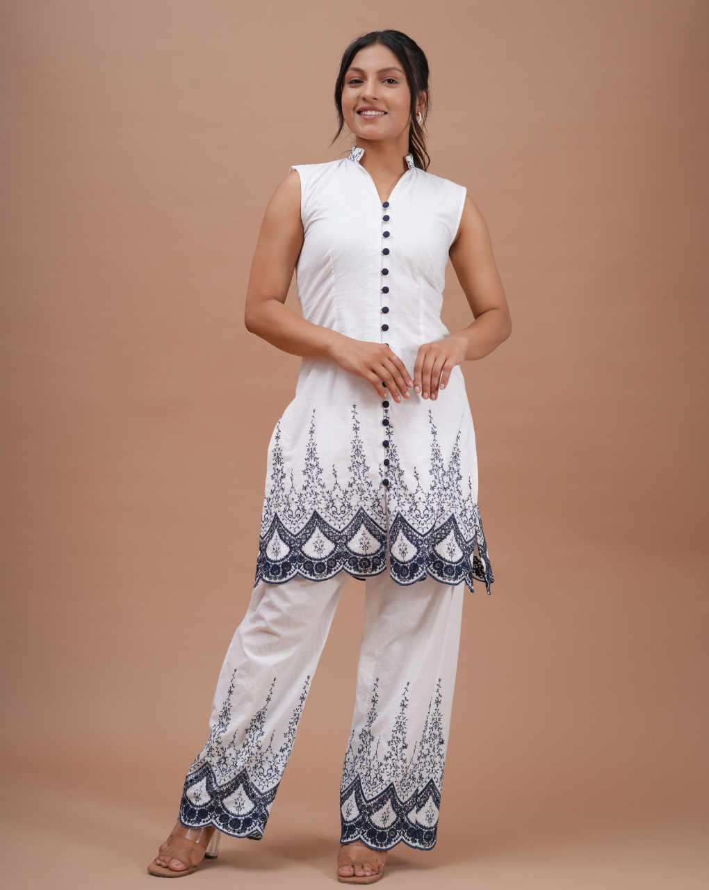 Woman wearing a white outfit with black patterns on a beige background