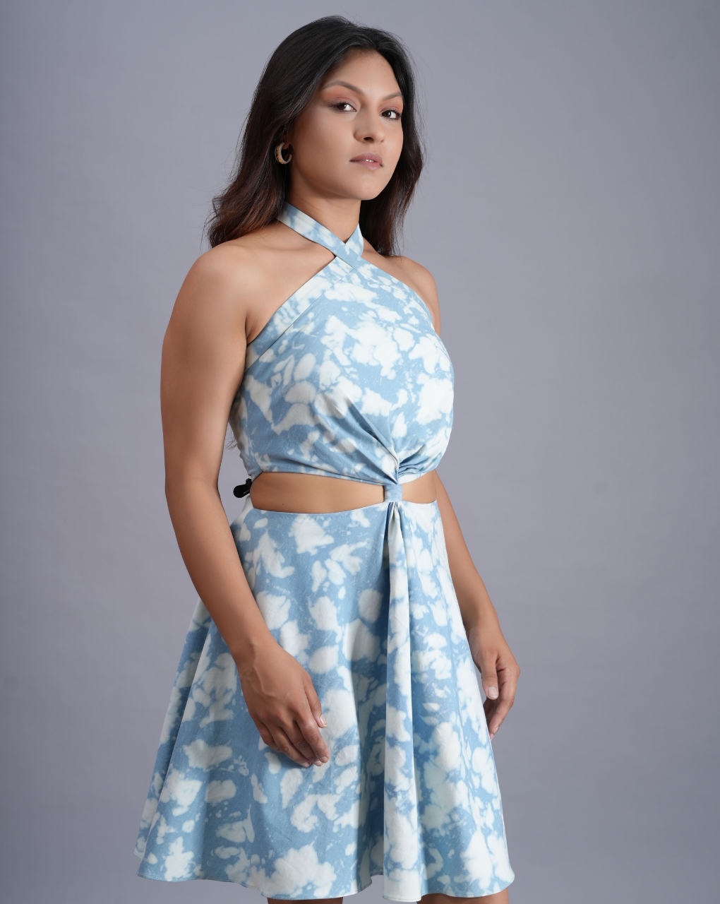 Woman wearing a blue floral dress against a gray background