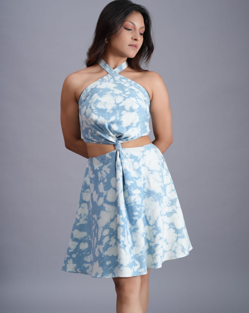 Woman wearing a blue floral dress against a gray background