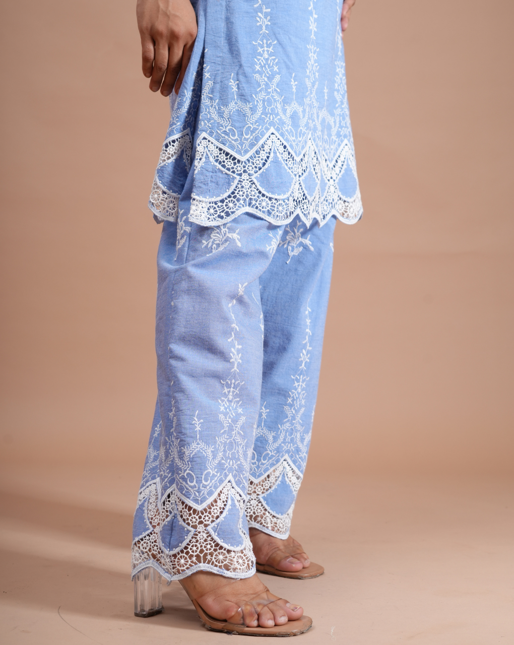 Light blue embroidered outfit on a beige background