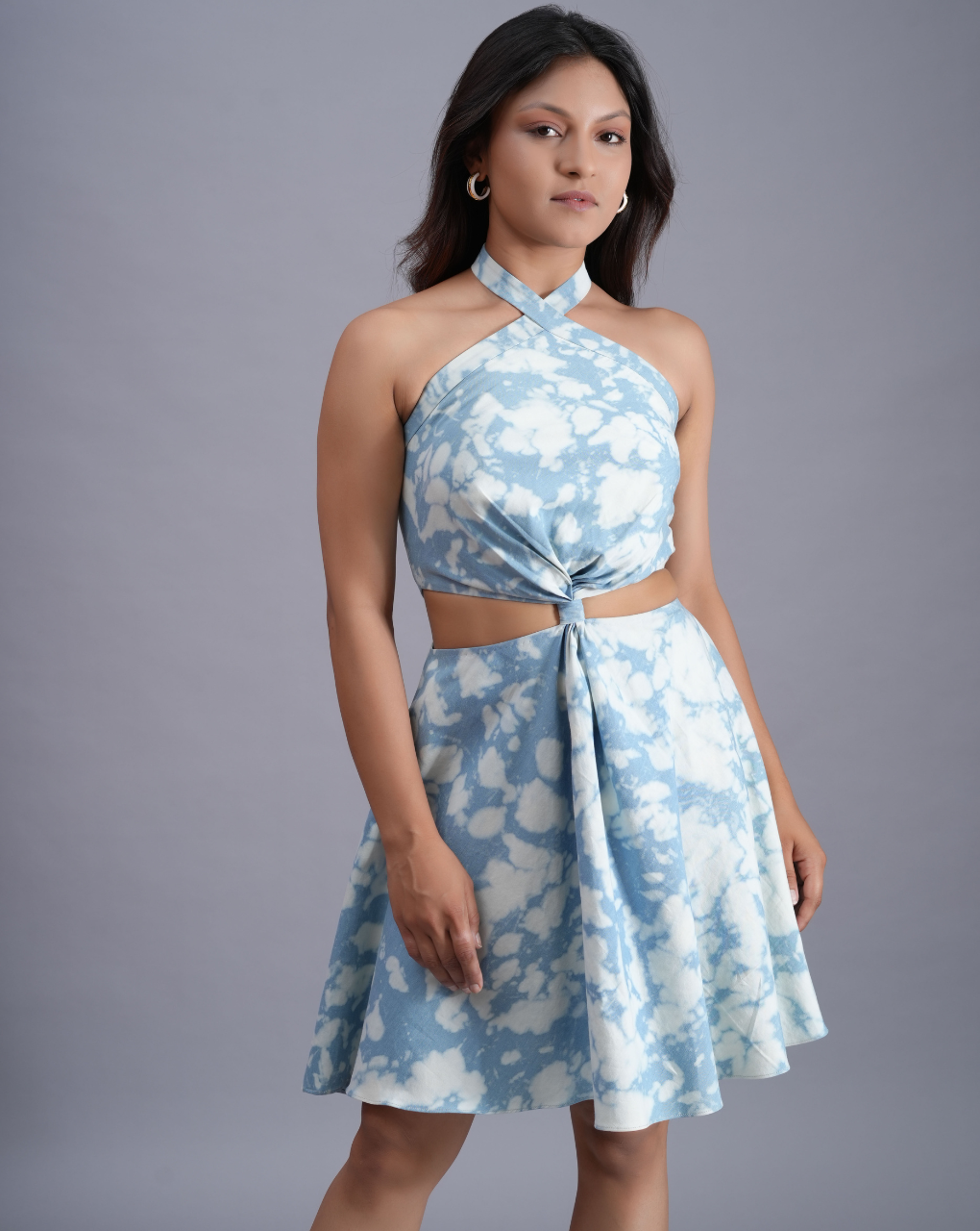 Woman wearing a blue floral dress against a gray background