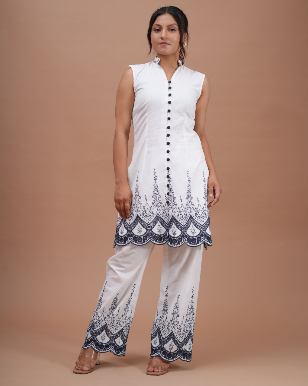 Woman wearing a white outfit with blue patterns on a brown background